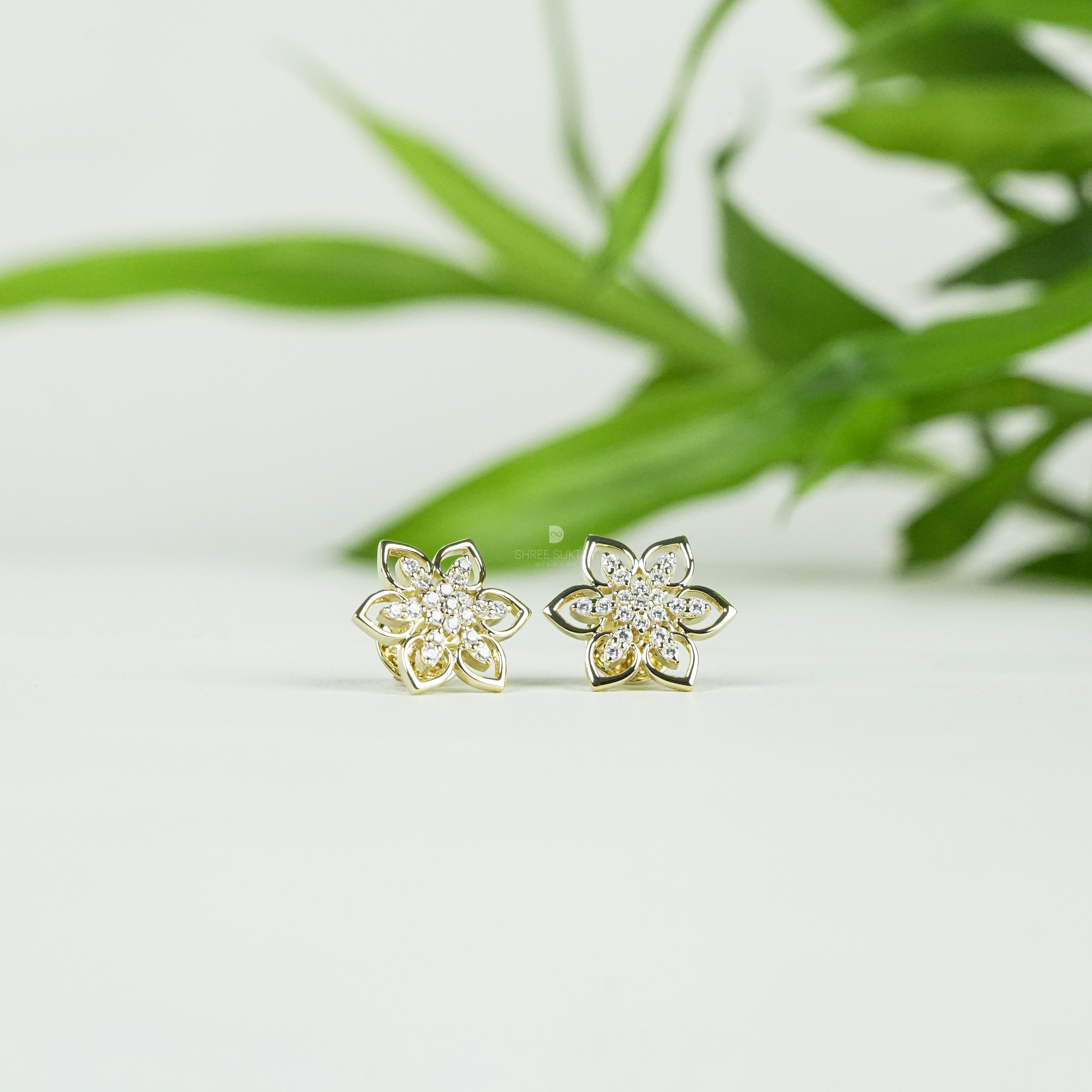 Elegant gold floral stud earrings featuring a delicate six-petal flower design adorned with sparkling cubic zirconia stones, perfect for everyday wear or special occasions. Crafted with fine attention to detail, these gold-plated earrings add a touch of timeless charm and sophistication. Ideal as a gift for women, these versatile studs pair beautifully with both casual and formal outfits, enhancing any jewelry collection.