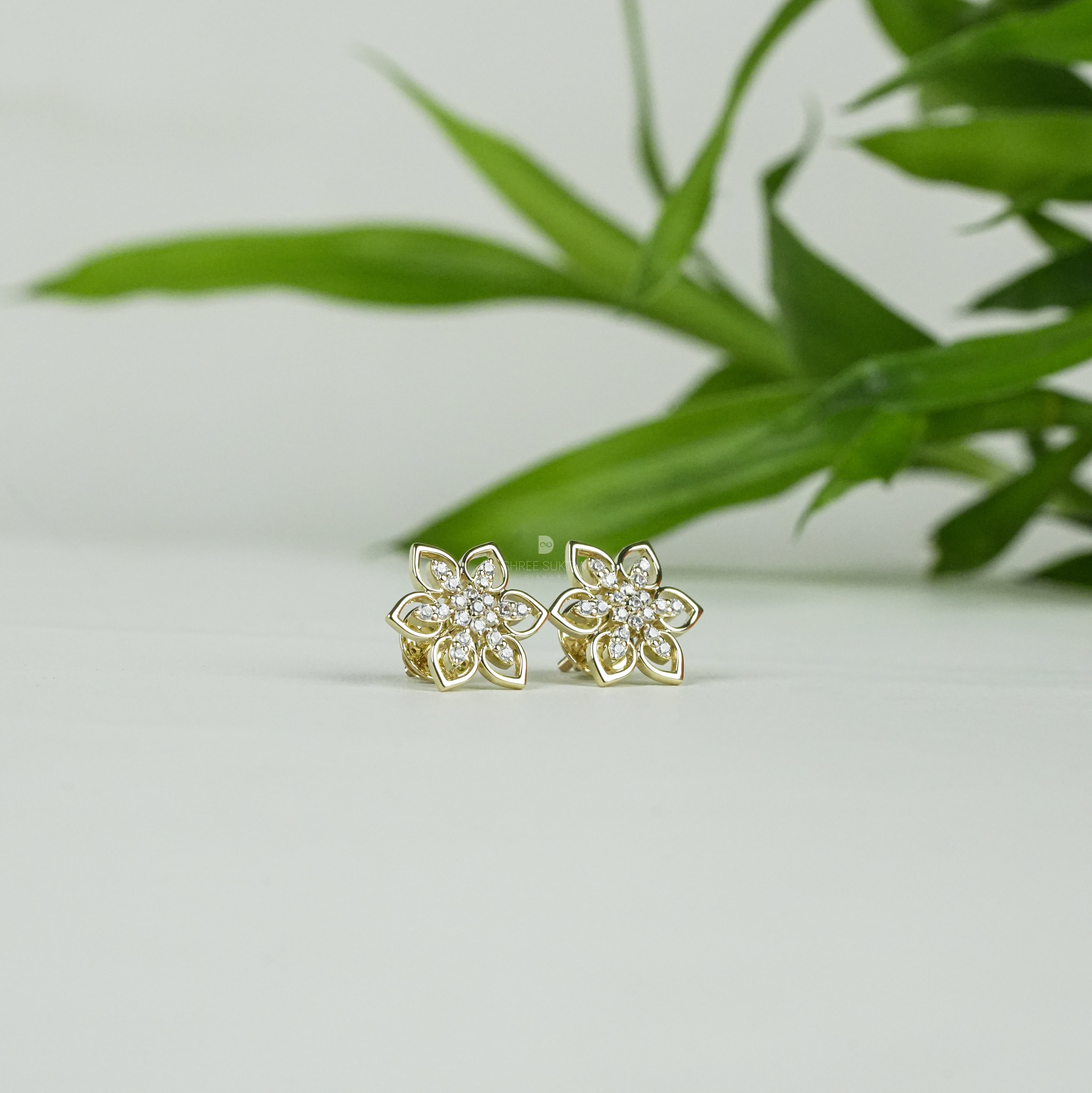 Elegant gold floral stud earrings featuring a delicate six-petal flower design adorned with sparkling cubic zirconia stones, perfect for everyday wear or special occasions. Crafted with fine attention to detail, these gold-plated earrings add a touch of timeless charm and sophistication. Ideal as a gift for women, these versatile studs pair beautifully with both casual and formal outfits, enhancing any jewelry collection.