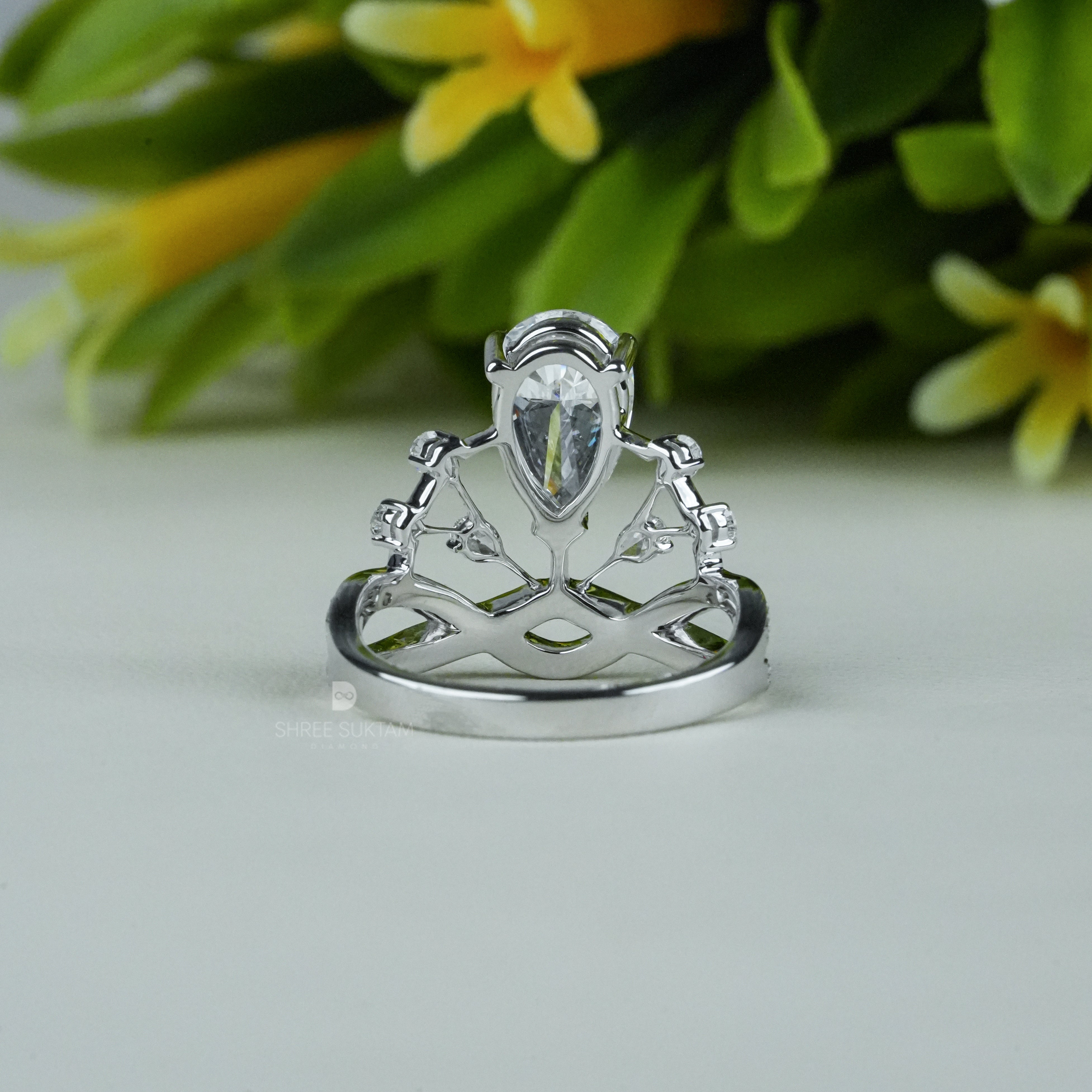 Elegant white gold tiara-inspired engagement ring featuring a stunning pear-shaped center diamond. The crown-style design is accentuated with smaller round diamonds on a double band adorned with pavé-set stones. Perfect for a bride who desires a regal and unique bridal look, this handmade piece combines royalty-inspired elegance with modern sophistication. Ideal as a proposal, promise, or anniversary ring.