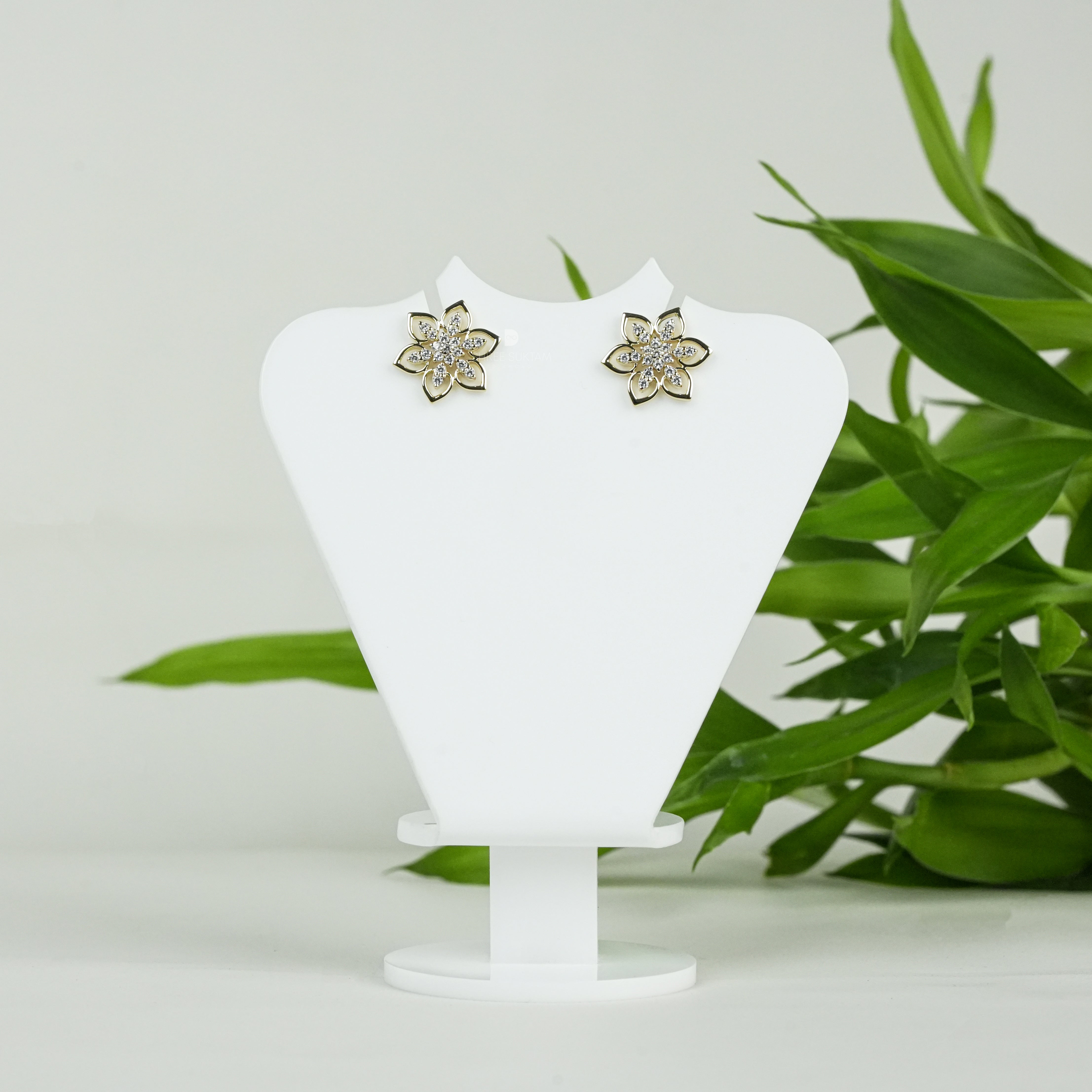 Elegant gold floral stud earrings featuring a delicate six-petal flower design adorned with sparkling cubic zirconia stones, perfect for everyday wear or special occasions. Crafted with fine attention to detail, these gold-plated earrings add a touch of timeless charm and sophistication. Ideal as a gift for women, these versatile studs pair beautifully with both casual and formal outfits, enhancing any jewelry collection.