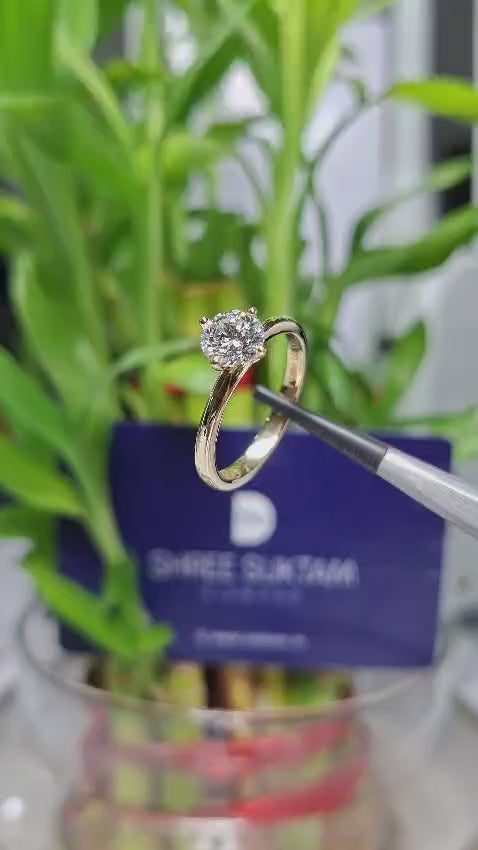 Round brilliant cut solitaire diamond engagement ring set in polished yellow gold band with four prongs, minimalist fine jewelry design, elegant proposal ring, timeless diamond ring for women.